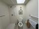 Bathroom with skylight, tile shower, toilet, and grab bars at 7234 Cloister Dr # 7234, Sarasota, FL 34231