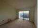 Bright bedroom with sliding glass doors to a patio, neutral carpet and blank walls at 7234 Cloister Dr # 7234, Sarasota, FL 34231