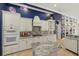 Modern kitchen with white cabinets, granite counters, and blue accent wall at 7319 Westminster Ct, University Park, FL 34201