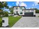 Modern home exterior with a paved driveway and lush landscaping at 577 Venice Ln, Sarasota, FL 34242