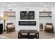 Cozy living room with a fireplace, built-in shelving and two armchairs at 577 Venice Ln, Sarasota, FL 34242
