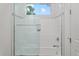 Bathroom with shower/tub combo, glass enclosure, and window at 577 Venice Ln, Sarasota, FL 34242