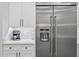 Sleek kitchen featuring a stainless steel refrigerator and white cabinetry at 577 Venice Ln, Sarasota, FL 34242