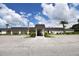 Community building exterior featuring a covered entrance and landscaping at 3961 Ashwood Ln # 44, Sarasota, FL 34232