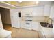Bright kitchen features white cabinets, appliances, and tile flooring at 3961 Ashwood Ln # 44, Sarasota, FL 34232