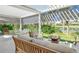 Covered patio with comfortable seating and a tranquil view of the water at 3924 Alamanda Dr, Sarasota, FL 34238