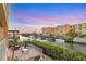 Wonderful backyard canal view with a dining set, brick patio, and lush greenery, perfect for relaxing at 14041 Bellagio Way # 214, Osprey, FL 34229