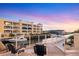 Enjoy the serene waterfront views from this balcony with seating, showcasing the building and boat docks at 14041 Bellagio Way # 214, Osprey, FL 34229