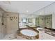 Bathroom showcases a soaking tub, shower, large mirrors, and vanity with marble countertops at 14041 Bellagio Way # 214, Osprey, FL 34229
