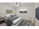 Bedroom features a ceiling fan, wood flooring, a large bed, and a flat-screen TV at 14041 Bellagio Way # 214, Osprey, FL 34229