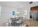 Dining area with stainless steel refrigerator, granite countertops, and modern chandelier at 14041 Bellagio Way # 214, Osprey, FL 34229