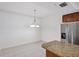 Dining room area featuring chandelier, granite countertop breakfast bar, and refrigerator at 14041 Bellagio Way # 214, Osprey, FL 34229