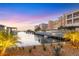 Exterior view of condos and boats docked along the water during sunset, with colorful sky at 14041 Bellagio Way # 214, Osprey, FL 34229
