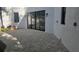 A minimalist backyard features a gray stone tile floor, a white wall, and sliding glass doors at 2318 Bay St, Sarasota, FL 34237