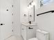 Bright bathroom featuring white vanity, toilet, black hardware, and white hexagon flooring at 2318 Bay St, Sarasota, FL 34237