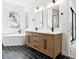 Bright bathroom featuring wood cabinets, black fixtures, a soaking tub, and decorative floors at 2318 Bay St, Sarasota, FL 34237