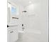 Clean bathroom with white tiled shower and floors, black hardware, and open view at 2318 Bay St, Sarasota, FL 34237
