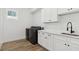 Well-lit laundry room with gray washer and dryer, white countertop and hardwood floors at 2318 Bay St, Sarasota, FL 34237