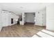 Spacious living area featuring light wood floors, white walls, a modern kitchen, and sleek black staircase at 2318 Bay St, Sarasota, FL 34237
