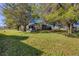 Landscaped backyard with home and large trees at 424 Logue Rd, Myakka City, FL 34251