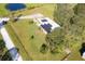 Aerial view of a house with solar panels, a pond, and lush greenery at 424 Logue Rd, Myakka City, FL 34251