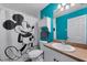 Bathroom with Mickey Mouse shower curtain and teal walls at 424 Logue Rd, Myakka City, FL 34251