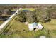 Aerial view showing a house, a pond, and surrounding trees at 424 Logue Rd, Myakka City, FL 34251
