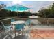 Deck with table and chairs overlooking a pond at 232 Woodland Dr, Osprey, FL 34229