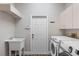 Laundry room with washer, dryer, utility sink and cabinets at 11332 Rivers Bluff Cir, Lakewood Ranch, FL 34202