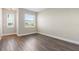 Bright bedroom featuring wood-look floors and a large window at 11332 Rivers Bluff Cir, Lakewood Ranch, FL 34202