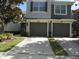 Two-story townhome with gray exterior, two-car garage, and landscaping at 2086 Kings Palace Dr # 2086, Riverview, FL 33578