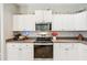 Well-equipped kitchen featuring white cabinets and stainless steel appliances at 2444 Vancouver Ln, North Port, FL 34286