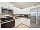 Clean kitchen with white cabinets, stainless steel appliances and corner pantry at 2444 Vancouver Ln, North Port, FL 34286