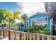 Exterior view of a charming cafe with vibrant blue walls, tropical plants, and a cozy outdoor seating area for customers at 1841 Buccaneer Dr, Sarasota, FL 34231