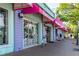 Sidewalk view showcasing shops with colorful awnings and displays, enticing pedestrians to browse the beachside retail offerings at 1841 Buccaneer Dr, Sarasota, FL 34231