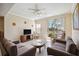 Comfortable living room features tile floors, neutral walls, ceiling fan and sliding glass doors to a screened balcony at 5552 Bentgrass Dr # 7-101, Sarasota, FL 34235