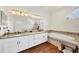 Elegant bathroom with double vanity, granite countertop, and oval soaking tub at 7341 Featherstone Blvd, Sarasota, FL 34238