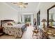 Main bedroom with floral bedding, large windows, and view of the backyard at 7341 Featherstone Blvd, Sarasota, FL 34238