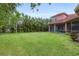 Large grassy backyard with mature trees at 7341 Featherstone Blvd, Sarasota, FL 34238