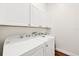 Bright laundry room with washer, dryer, and ample cabinets at 7341 Featherstone Blvd, Sarasota, FL 34238