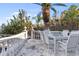 Outdoor dining patio with stone flooring and lush landscaping at 8213 Midnight Pass Rd, Sarasota, FL 34242