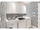 Bright laundry room with washer, dryer, and stylish wallpaper at 8213 Midnight Pass Rd, Sarasota, FL 34242