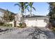 House exterior with double garage and manicured landscaping at 8213 Midnight Pass Rd, Sarasota, FL 34242
