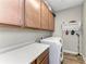 Laundry room with upper cabinets, washer, dryer, and folding counter at 5016 Savona Run, Bradenton, FL 34211