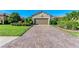 Exterior view of a house with a paver driveway and nicely landscaped front yard at 5016 Savona Run, Bradenton, FL 34211