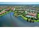 Aerial view of community with lake, pool, and clubhouse at 5016 Savona Run, Bradenton, FL 34211