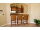Small kitchenette with granite counters and wicker barstools at 5122 Northridge Rd # 207, Sarasota, FL 34238