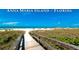 Wooden boardwalk leads to beautiful beach with white sand and blue water at 2911 74Th W St # 2276, Bradenton, FL 34209