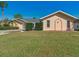 Tan house with grey roof, landscaped yard, and driveway at 2837 Cabaret St, Port Charlotte, FL 33948