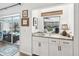 Wet bar area with granite countertop, white cabinets, and easy access to outdoor pool and seating at 218 Brandywine Circle, Englewood, FL 34223